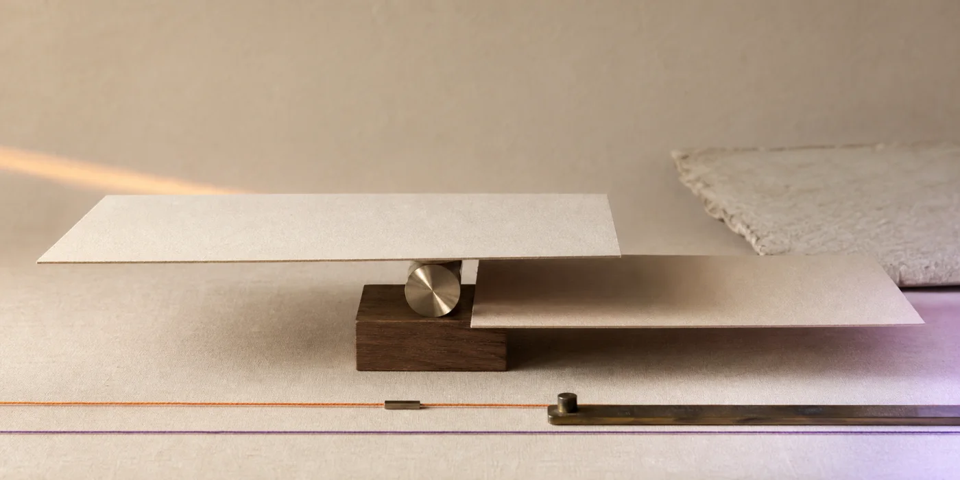 Planos de papel e metal equilibrados sobre uma base, representando acordo e responsabilidades